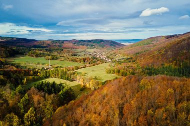Vadideki küçük dağ köyü renkli sonbahar yapraklarıyla çevrili. Sonbahar mevsiminde doğa manzarası