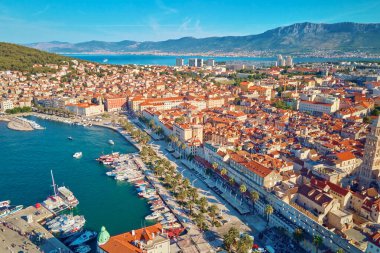 Hırvatistan 'ın Split kentinin hava manzarası. Arkasında dağlar olan kıyı turistik kenti şehir manzarası. Adriyatik Denizi yakınlarındaki tarihi kırmızı çatılı eski kasaba