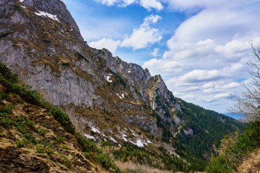 Kayalık kayalıkları ve karla kaplı engebeli bir dağ yamacı. Polonya 'daki Tatra Ulusal Parkı. Doğal manzara.