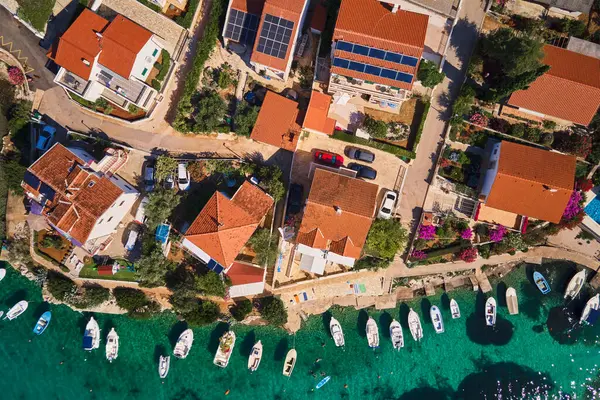 Deniz kıyısında kuş bakışı manzara ve deniz kıyısında küçük bir kasaba. Kırmızı çatılı evleri ve kıyıya yakın tekneleri olan kıyı köyünün havadan görünüşü. Hırvatistan 'ın Adriyatik Denizi üzerindeki Rogoznica kasabası