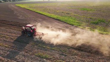 Kırmızı traktör tarlada çalışıyor, kuru toprak ekip biçiyor, hava manzarası var. Tarım sektörü konsepti. Küçük tarım kavramı