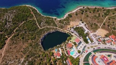 Hırvatistan 'ın Rogoznica kentindeki Marina Frapa yakınlarındaki Ejderha Gözlü Gölü' nün havadan görünüşü. Sahil kasabası ve yatları olan deniz manzarası. Adriyatik Denizi 'nde yaz tatili için turistik şehir