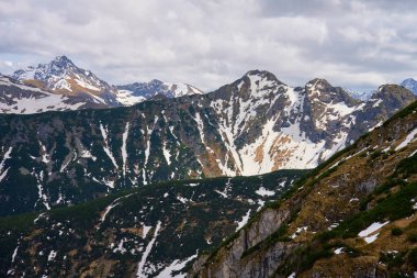 Bulutlu gökyüzüne karşı karla kaplı dağ sırasının panoramik görüntüsü. Polonya, Zakopane 'deki Tatra dağları. Giewont dağ zirvesi. Doğal manzara.