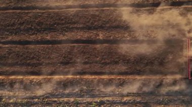 Kırmızı traktör tarlada çalışıyor, kuru toprak ekip biçiyor, hava manzarası var. Tarım sektörü konsepti. Küçük tarım kavramı