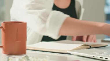 Defterde çizim yapan kişi uzaktan bilgisayarla masa başında çalışıyor. Ev ofisinde serbest bir iş. Grafik tasarımcısı çizimi