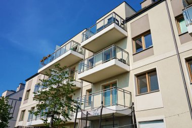 Güneşli bir günde balkonları ve yeşil ağaçları olan modern bir apartman. Wroclaw, Polonya 'da bir yerleşim yeri. Gayrimenkul kredisi