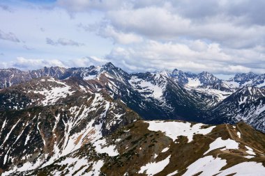 Bulutlu gökyüzüne karşı karla kaplı dağ sırasının panoramik görüntüsü. Polonya, Zakopane 'deki Tatra dağları. Giewont dağ zirvesi. Doğal manzara.