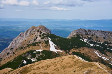 Bulutlu gökyüzünün altında dağ zirvesine çıkan engebeli yürüyüş yolu. Polonya, Zakopane 'deki Tatra dağları. Giewont dağ zirvesi. Doğal manzara.