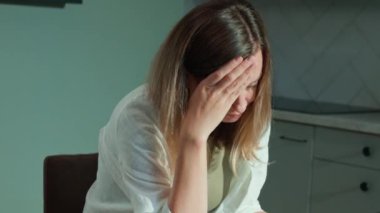 Stresli kadın faturaları evde gözden geçiriyor. Faturaları düzenleyen kadın, mutfak masasında dizüstü bilgisayar ve kağıt belgelerle oturuyor. Bütçe belirleme ve kişisel finans yönetimi kavramı