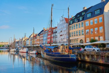 Nyhawn Limanı - Kopenhag, Danimarka 'daki ünlü turistik bölge. Gündoğumunda renkli binalarla Nyhavn Kanalı 'na yanaşan tekneler. Kopenhag, Danimarka - 26 Haziran 2024