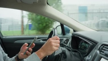 Sürücü araba kullanırken akıllı telefon kullanıyor, telefonundaki mesajlar dikkatini dağıtıyor. Tehlikeli araç kullanma, trafik kurallarının ihlali.