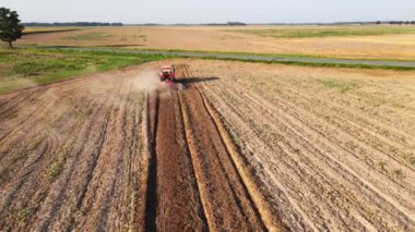 Kırmızı traktör tarlada çalışıyor, kuru toprak ekip biçiyor, hava manzarası var. Tarım sektörü konsepti. Küçük tarım kavramı