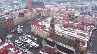 Avrupa 'nın kış mevsiminde kırmızı çatılı binalarla kaplı, karla kaplı hava manzarası. Noel pazarı ve süslü sokaklar Wroclaw şehri, Polonya