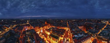 Aydınlatılmış tezgahlar, şenlik ağacı ve Wroclaw, Polonya 'daki tarihi binalarla geceleyin Noel pazarının havadan görünüşü. Kış mevsiminde süslü caddeleri olan Avrupa kasabası