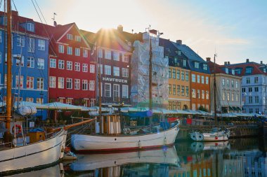 Nyhawn Limanı - Kopenhag, Danimarka 'daki ünlü turistik bölge. Gündoğumunda renkli binalarla Nyhavn Kanalı 'na yanaşan tekneler. Kopenhag, Danimarka - 26 Haziran 2024
