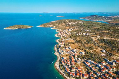 Sahil köyü ve kıyı şeridi boyunca tekneleri olan Adriyatik kıyı şeridinin havadan görüntüsü. Hırvatistan 'ın Adriyatik Denizi kıyısındaki Rogoznica kentinin panoraması. Yaz yolculuğu konsepti