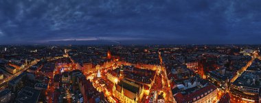 Aydınlatılmış tezgahlar, şenlik ağacı ve Wroclaw, Polonya 'daki tarihi binalarla geceleyin Noel pazarının havadan görünüşü. Kış mevsiminde süslü caddeleri olan Avrupa kasabası