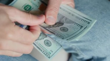 Yüz dolarlık banknotları saymak için yakın plan çekimler. Amerikan dolarlarını elinde tutan adam. Para yönetimi, zenginlik veya mali işlemler kavramı