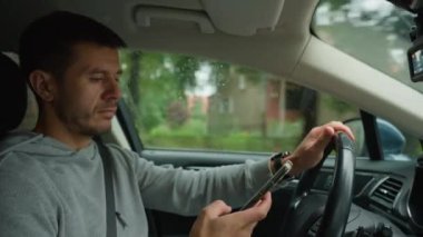Sürücü araba kullanırken akıllı telefon kullanıyor, telefonundaki mesajlar dikkatini dağıtıyor. Tehlikeli araç kullanma, trafik kurallarının ihlali.