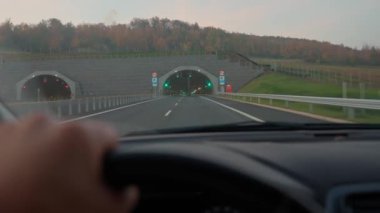 Otobanda giden arabanın görüntüsü ve tünel girişine yaklaşıyoruz. Yoldaki erkek sürücünün ilk görüntüsü. Yolculuk