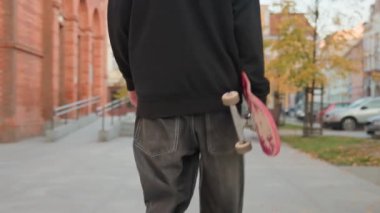 Elinde çizik bir kaykayla şehir caddesinde yürüyen bol kotlu bir kaykaycı. Ergen kaykay yapıyor. Gençlik alt kültürü kavramı