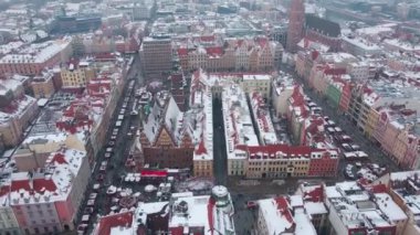 Avrupa 'nın kış mevsiminde kırmızı çatılı binalarla kaplı, karla kaplı hava manzarası. Noel pazarı ve süslü sokaklar Wroclaw şehri, Polonya