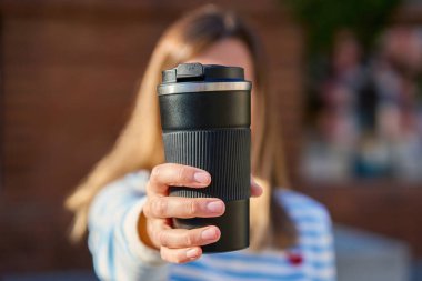 Dışarıda elinde sade kahve fincanı tutan bir kadın. Çevre dostu yaşam tarzı kavramı