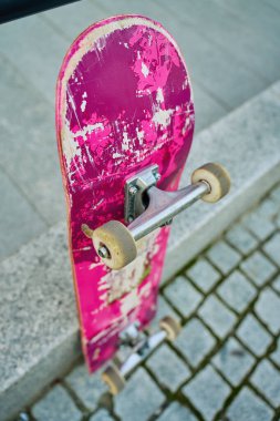 Şehir caddesinde taş duvara karşı çizilmiş pembe kaykay kullanılmış. Kentsel spor ve gençlik alt kültür kavramı