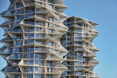 Mavi gökyüzüne karşı geometrik şekilli modern yerleşim binası cephesi. Çağdaş mimari tasarım. Minimalist İskandinav mimarisinin ayrıntıları