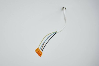 Beyaz duvardan yayılan elektrik kablolarının yakın çekimi. Dairenin tadilatı sırasında elektrik işi. Yeni dairede elektrik kablosu