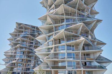 Temiz mavi gökyüzüne karşı geometrik tasarımı olan modern apartmanların düşük açılı görüntüsü. Çağdaş mimari tasarım