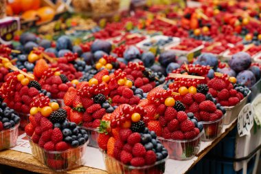 Çilekler, ahududular, yabanmersinleri ve böğürtlenleri çiftçi pazarında sepetlere yerleştirilmiş taze böğürtlenler.
