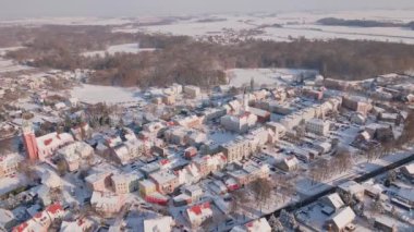 Şehir merkezinin ve yerleşim yerlerinin havadan görünüşü. Evleri ve caddeleri karla kaplı. Küçük Avrupa kasabasında kış mevsimi