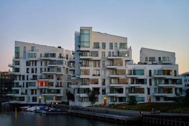 Kopenhag, Danimarka 'da deniz kıyısındaki modern yerleşim yerleri. Çağdaş İskandinav mimarisi. Gün batımında şehrin panoramik manzarası