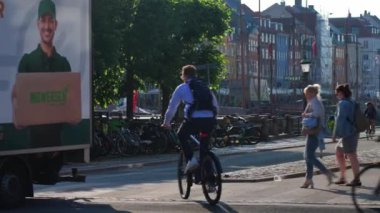 Yayalar, bisiklet yolunda bisiklet süren insanlar ve Kopenhag 'da toplu taşıma araçları. Danimarka 'da şehir trafiği. Sokakta yaşayan bir şehir. Kopenhag, Danimarka - 26 Haziran 2024