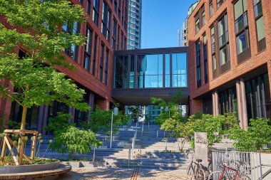 Modern kırmızı tuğla binanın yanındaki yemyeşil ağaç. Konut binası cephesi. Çağdaş mimari şehir tasarımı