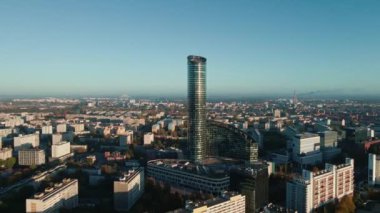 Şehir manzarasına karşı yalnız, modern gökdelen, hava manzarası. Şehrin üstündeki modern yüksek katlı ofis binasının cam cephesi. Wroclaw, Polonya 'daki Gökyüzü Kulesi kuş bakışı