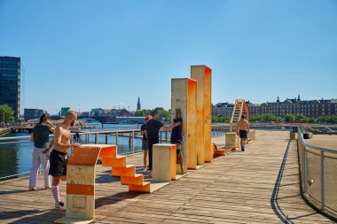 Danimarka 'nın Kopenhag kentindeki ahşap iskelede antrenman yapan sporcular. İnsanlar yaz günü şehir setinde spor egzersizleri yapıyorlar. Kopenhag, Danimarka - 26 Haziran 2024