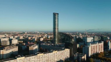 Şehir manzarasına karşı yalnız, modern gökdelen, hava manzarası. Şehrin üstündeki modern yüksek katlı ofis binasının cam cephesi. Wroclaw, Polonya 'daki Gökyüzü Kulesi kuş bakışı