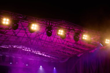 Metal kirişe monte edilmiş profesyonel sahne ışıklandırması. Konser sahnesinde parlak ışıklar. Canlı müzik etkinliği
