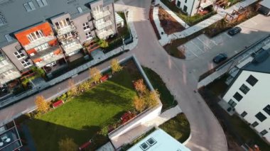 Canlı sonbahar ormanı yakınlarındaki modern yerleşim yerleri, hava manzarası. Küçük Avrupa kasabasındaki dağların yakınındaki yeşil alanları olan banliyö çevre dostu apartmanlar.