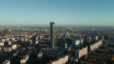 Şehir manzarasına karşı yalnız, modern gökdelen, hava manzarası. Şehrin üstündeki modern yüksek katlı ofis binasının cam cephesi. Wroclaw, Polonya 'daki Gökyüzü Kulesi kuş bakışı
