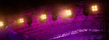 Metal kirişe monte edilmiş profesyonel sahne ışıklandırması. Konser sahnesinde parlak ışıklar. Canlı müzik etkinliği