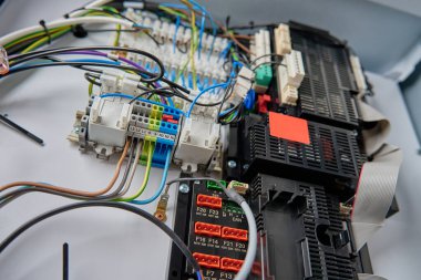 Elektrik kontrol panelinin kablo sistemi ve devre kartının yakın görüntüsü. Otomasyon ve çeşitli sistemlerin düzenlenmesi için kullanılan elektrik bileşenleri