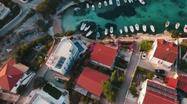 Kırmızı çatılı evleri, turkuaz suları ve kıyı boyunca tekneleri olan kıyı köyünün havadan görünüşü. Hırvatistan 'ın Adriyatik Denizi kıyısındaki Rogoznica kentinin panoraması. Yaz tatili kavramı