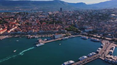 Hırvatistan 'ın Split kentinin hava manzarası. Arka planda tekneler ve dağlarla dolu kıyı turistik kenti manzarası. Adriyatik Denizi yakınlarındaki tarihi kırmızı çatılı eski kasaba
