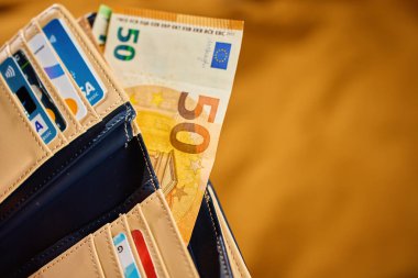 İçinde avro banknotları ve kredi kartları olan bir cüzdan. Cüzdanını nakit parayla kapat. Kişisel finans, nakit ödemeler ve tasarruf kavramı