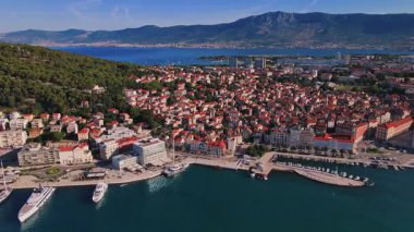 Hırvatistan 'ın Split kentinin hava manzarası. Arka planda tekneler ve dağlarla dolu kıyı turistik kenti manzarası. Adriyatik Denizi yakınlarındaki tarihi kırmızı çatılı eski kasaba