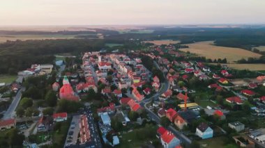 Gün doğumunda banliyöde küçük bir kasabanın havadan görünüşü. Avrupa 'nın eski kasaba ve kilisesi olan ana meydanı. Renkli evleri olan şehir manzarası. Katy Wroclawskie, Polonya