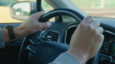 Sürücü erkek, direksiyonu sıkıca tutuyor ve sollamadan önce dönüş sinyalini açıyor. Seyahat, ulaşım ve yol güvenliği kavramı